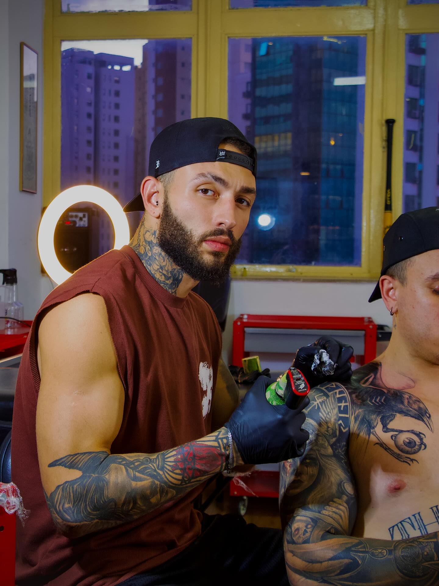 Bruno Borém tattooing a client